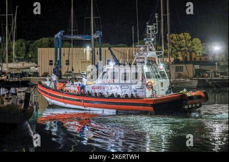 Roccella Jonica, Italien. 14. Oktober 2022. Ein Patrouillenboot der Küstenwache mit Migranten an Bord. 64 irreguläre Migranten, hauptsächlich aus Afghanistan, dem Iran, Syrien und dem Irak, wurden von der italienischen Küstenwache unterstützt und landeten in „Porto delle Grazie“, dem Hafen von Roccella Ionica, der aus der Türkei kam. Die Menschen wurden von Doctors Without Borders und dem lokalen Komitee des Roten Kreuzes unterstützt.Quelle: SOPA Images Limited/Alamy Live News Stockfoto