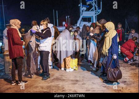 Roccella Jonica, Italien. 14. Oktober 2022. Migranten bei ihrer Ankunft im Hafen gesehen. 64 irreguläre Migranten, hauptsächlich aus Afghanistan, dem Iran, Syrien und dem Irak, wurden von der italienischen Küstenwache unterstützt und landeten in „Porto delle Grazie“, dem Hafen von Roccella Ionica, der aus der Türkei kam. Die Menschen wurden von Doctors Without Borders und dem lokalen Komitee des Roten Kreuzes unterstützt.Quelle: SOPA Images Limited/Alamy Live News Stockfoto