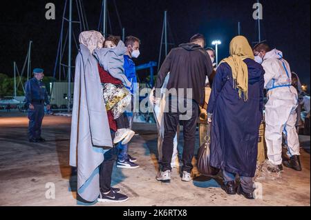 Roccella Jonica, Italien. 14. Oktober 2022. Migranten bei ihrer Ankunft im Hafen gesehen. 64 irreguläre Migranten, hauptsächlich aus Afghanistan, dem Iran, Syrien und dem Irak, wurden von der italienischen Küstenwache unterstützt und landeten in „Porto delle Grazie“, dem Hafen von Roccella Ionica, der aus der Türkei kam. Die Menschen wurden von Doctors Without Borders und dem lokalen Komitee des Roten Kreuzes unterstützt.Quelle: SOPA Images Limited/Alamy Live News Stockfoto
