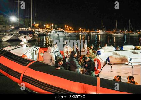 Roccella Jonica, Italien. 14. Oktober 2022. Migranten mit Wärmedecken auf einem Patrouillenboot gesehen. 64 irreguläre Migranten, hauptsächlich aus Afghanistan, dem Iran, Syrien und dem Irak, wurden von der italienischen Küstenwache unterstützt und landeten in „Porto delle Grazie“, dem Hafen von Roccella Ionica, der aus der Türkei kam. Die Menschen wurden von Doctors Without Borders und dem lokalen Komitee des Roten Kreuzes unterstützt.Quelle: SOPA Images Limited/Alamy Live News Stockfoto