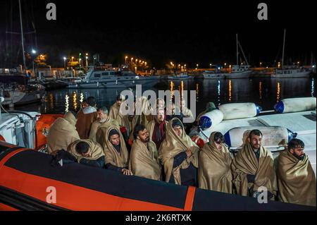 Roccella Jonica, Italien. 14. Oktober 2022. Migranten sahen, wie sie sich auf dem Patrouillenboot mit Decken bedeckten. 64 irreguläre Migranten, hauptsächlich aus Afghanistan, dem Iran, Syrien und dem Irak, wurden von der italienischen Küstenwache unterstützt und landeten in „Porto delle Grazie“, dem Hafen von Roccella Ionica, der aus der Türkei kam. Die Menschen wurden von Doctors Without Borders und dem lokalen Komitee des Roten Kreuzes unterstützt.Quelle: SOPA Images Limited/Alamy Live News Stockfoto