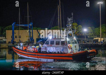 Roccella Jonica, Italien. 14. Oktober 2022. Ein Patrouillenboot der Küstenwache mit Migranten an Bord. 64 irreguläre Migranten, hauptsächlich aus Afghanistan, dem Iran, Syrien und dem Irak, wurden von der italienischen Küstenwache unterstützt und landeten in „Porto delle Grazie“, dem Hafen von Roccella Ionica, der aus der Türkei kam. Die Menschen wurden von Doctors Without Borders und dem lokalen Komitee des Roten Kreuzes unterstützt.Quelle: SOPA Images Limited/Alamy Live News Stockfoto
