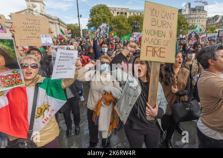 London, Großbritannien. Oktober 2022. Eine große Menschenmenge versammelt sich im Zentrum Londons zu einem Protest, der die Rechte der iranischen Frauen unterstützt und gegen das Regime der Islamischen Republik kämpft. Demonstranten halten Schilder wie „MAN KANN FRAUEN NICHT VERBRENNEN, DIE AUS FEUER GEMACHT WURDEN“ und „DIE BRITISCHE BOTSCHAFT DES KÖNIGREICHS HÖRT AUF, MULLAH ZU UNTERSTÜTZEN“. Iranische Fahnen mit Löwen- und Sonnenemblem sind sichtbar und symbolisieren den Widerstand gegen die aktuelle Regierung. Der Protest hebt Solidarität, die Stärkung der Geschlechter und den politischen Widerstand hervor. Penelope Barritt/Alamy Live News Stockfoto