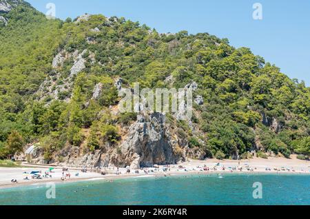 Olympos, Antalya, Türkei – 16. August 2021. Landschaft in Olympos Feriendorf in der Provinz Antalya der Türkei. Blick auf den Strand mit Menschen und Berg Stockfoto