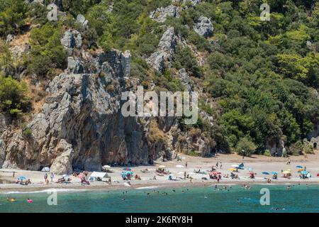 Olympos, Antalya, Türkei – 16. August 2021. Landschaft in Olympos Feriendorf in der Provinz Antalya der Türkei. Blick auf den Strand mit Menschen und Berg Stockfoto