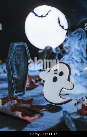 Gruseliger Halloween Hintergrund. Friedhof und Grabsteine bei beängstigender Nacht und bei blauem Mondschein. Fliegende niedliche gruselige Monster Geist. Fledermaus Silhouetten. Cemeter Stockfoto