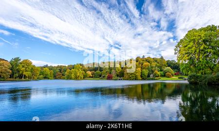 Panorama von bunten Bäumen und Sträuchern in goldenen Herbstfarben in Stourhead, Wiltshire, Großbritannien am 15. Oktober 2022 Stockfoto