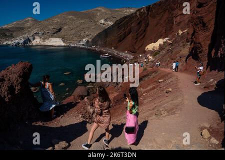 Touristen besuchen und genießen ein warmes Wetter in Red Beach, südlich von Santorini Island. Santorini ist eine der Kykladen-Inseln in der Ägäis Stockfoto