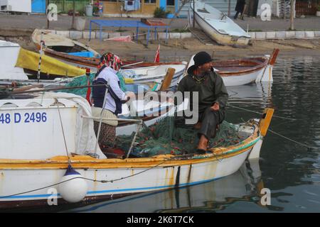 Bodrum, Türkei. 30. Januar 2020: Nach der Rückkehr vom Fischfang pflückt der Fischer Fische aus den Netzen im Boot. Stockfoto