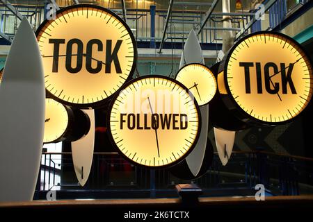 Uhren mit Inschriften "tik, tok und gefolgt".Gelb und Blau Stockfoto