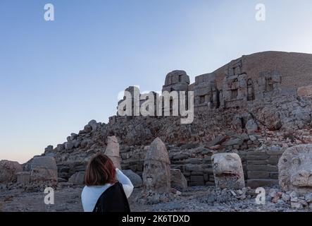 Eine Frau fotografiert Statuen im Mount Nemrut National Park. Aufgenommen in die UNESCO-Liste des Weltkulturerbes. Stockfoto