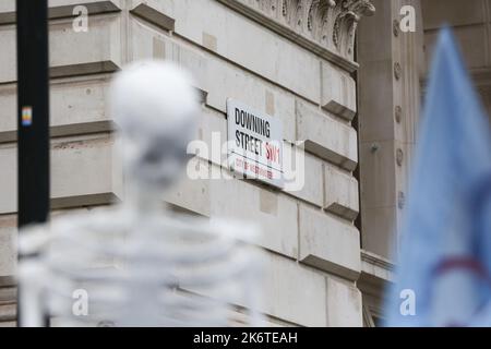 London, Großbritannien. 14. Oktober 2022. Ein Skelett, das außerhalb der Downing Street gesehen wird, als Aktivisten in Westminster gegen die Klimakrise und steigende Energiekosten demonstrieren. Kredit: SOPA Images Limited/Alamy Live Nachrichten Stockfoto