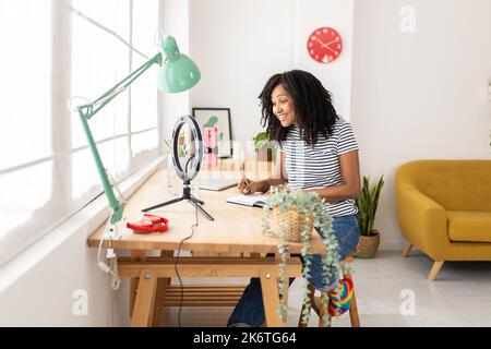 Junge Erwachsene Influencer Frau im Gespräch mit Mobiltelefon Aufnahme Video für Blog Stockfoto