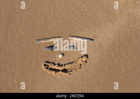 Zeichnung eines menschlichen Gesichts im Sand am Strand, Norfolk, England, Vereinigtes Königreich Stockfoto