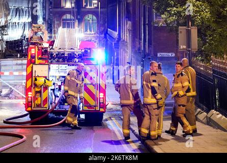Feuerwehrleute am Schauplatz eines Brandes im Stadtzentrum von Leeds, der in den obersten Stockwerken eines verstürzten Gebäudes in der Cookridge Street in der Nähe des Millennium Square ausbrach Bilddatum: Samstag, 15. Oktober 2022. Stockfoto
