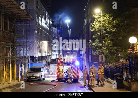 Feuerwehrleute am Schauplatz eines Brandes im Stadtzentrum von Leeds, der in den obersten Stockwerken eines verstürzten Gebäudes in der Cookridge Street in der Nähe des Millennium Square ausbrach Bilddatum: Samstag, 15. Oktober 2022. Stockfoto