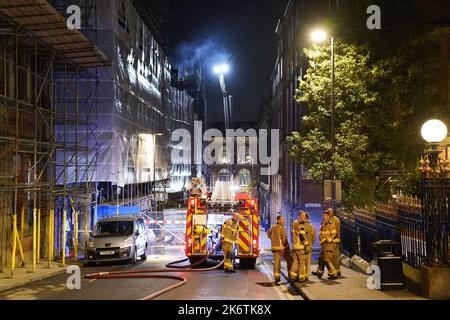 Feuerwehrleute am Schauplatz eines Brandes im Stadtzentrum von Leeds, der in den obersten Stockwerken eines verstürzten Gebäudes in der Cookridge Street in der Nähe des Millennium Square ausbrach Bilddatum: Samstag, 15. Oktober 2022. Stockfoto