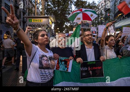 Barcelona, Spanien. 15. Oktober 2022. Demonstranten halten während der Demonstration Plakate. Hunderte von Menschen haben im Zentrum von Barcelona demonstriert Einen Monat nach dem Mord an Mahsa Amini im Iran in den Händen der "Mordpolizei" fordern Demonstranten unter anderem Gerechtigkeit. Kredit: SOPA Images Limited/Alamy Live Nachrichten Stockfoto