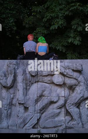 Deutschland, Berlin, 14. 08. 2021, Marx-Engels-Forum, Relief, zwei Mädchen mit grünen und roten Haaren, anlässlich der Hanfparade Stockfoto