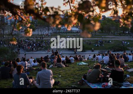 Deutschland, Berlin, 09. 05. 2021, Sonntagnachmittag im Mauerpark, Wiese am Hang, Besucher, Blüten, blühender Baum, Abendlicht Stockfoto