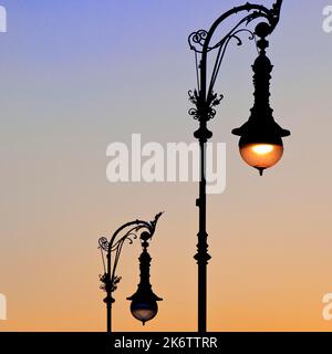 Alte Berliner Gaslaternen in der Straße unter den Linden bei Sonnenuntergang, Berlin, Deutschland Stockfoto