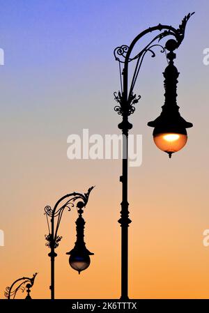 Alte Berliner Gaslaternen in der Straße unter den Linden bei Sonnenuntergang, Berlin, Deutschland Stockfoto