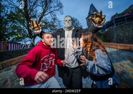 PRODUKTION - 15. Oktober 2022, Hessen, Mühltal: Krzysztof (l) und Jana werden von einem Performer im Frankenstein-Kostüm verfolgt. Andreas Biel ist 204cm groß und tritt erstmals als 'Frankenstein' auf. Schloss Frankenstein ist seit 1977 Gastgeber der Halloween-Veranstaltung, in diesem Jahr zum 43.. Mal (21. Oktober-Nov. 6, 2022). Bei einer Generalprobe hat der Organisator das gruselige Ereignis mit einem besonderen Publikum durchgemacht. Foto: Andreas Arnold/dpa Quelle: dpa picture Alliance/Alamy Live News Stockfoto