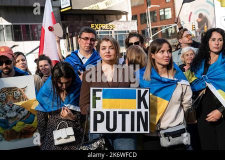 New York, New York, USA. 15. Oktober 2022. Aktivisten schufen auf dem Times Square den "Circle of Defense", der gegen die russische Aggression gegen die Ukraine protestierte. Die Menschen entrollten eine riesige ukrainische Flagge und unterschrieben sie. Unter den Teilnehmern war Roma Horodenskyi, ukrainische Marine, die 36 in Mariupol diente, verletzt wurde, linkes Bein und rechten Arm verlor, Zeit als Kriegsgefangener verbrachte, im Austausch mit Kriegsgefangenen an die Ukraine übergeben wurde und jetzt in den USA in Rehabilitation ist, Er hat bereits eine Beinprothese erhalten und wartet auf einen prothetischen Arm. (Bild: © Fotograf Lev Radin/Pacifi Stockfoto