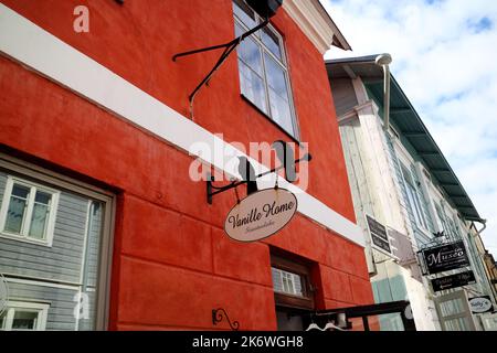 Zwei schwarze Krähen sitzen auf einem Ladenschild in einem alten denkmalgeschützten Gebäude in Porvoo, Finnland Stockfoto