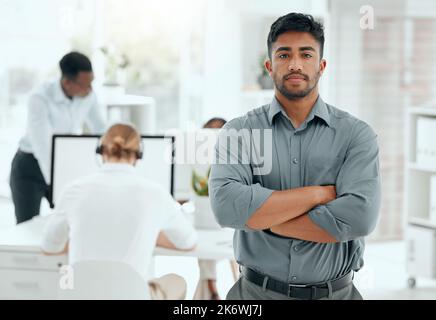 Vertrauen bringt Sie an Orte, die Sie sonst nicht erreichen würden. Ein Porträt eines hübschen jungen Geschäftsmannes, der mit gefalteten Armen im Büro steht. Stockfoto