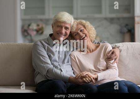 Porträt eines pensionierten Paares posieren für die Kamera im modernen Zuhause Stockfoto