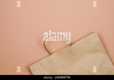 Banner auf beigem Hintergrund mit ökologischem Papierbeutel für Saison- und Urlaubseinkäufe. Das Konzept der Herbstverkäufe, Rabatte, umweltfreundliches Einkaufen. Stockfoto