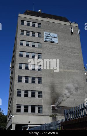 Altes Gebäude des Peter MacCallum Cancer Institute, das heute Teil des St. Vincent's Hospital ist, während Rauch aus der Seite des Gebäudes aufbläst Stockfoto