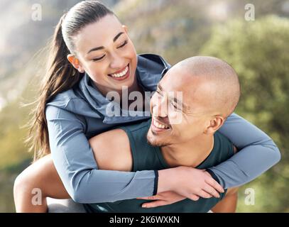 Wir machen es zu unserer Arbeit, jeden Tag aktiv zu sein. Ein Mann, der seine Freundin auf dem Rücken trägt, während er zum Training unterwegs ist. Stockfoto