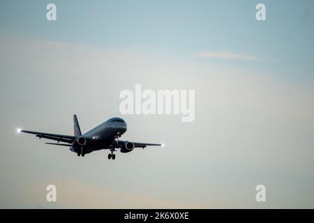Die Silhouette eines Passagierflugzeugs, das vor dem Hintergrund des Sonnenuntergangs landet. Stockfoto