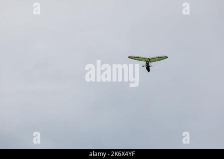 Motorbetriebener Drachenflieger, der in blauem Himmel fliegt. Motorisierter Hängegleiter, ultraleichtes Trike-Drilling, Kopieplatz. Extremes Tourismuskonzept Stockfoto