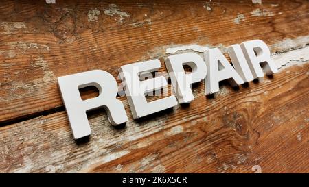 Reparatur - Text auf altem schäbigen Holz Stockfoto