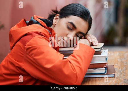 Ich schließe nur ein wenig meine Augen. Eine junge Studentin, die am College in einer Bibliothek schläft. Stockfoto