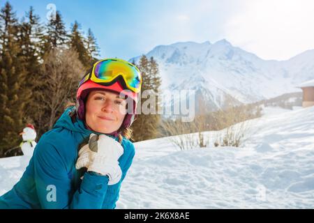 Fröhliche lächelnde Frau im Skioutfit im Bergurlaub Stockfoto