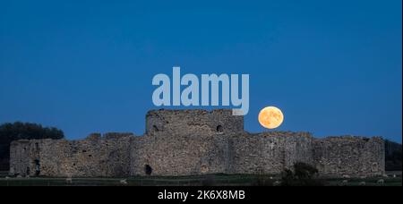 Oktober der Vollmond der Jäger steigt hinter den Ruinen von Camber Castle in der Nähe von Rye im Osten von Sussex im Südosten Englands auf Stockfoto