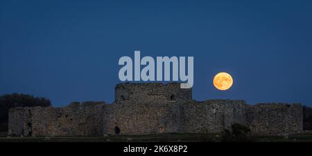 Oktober der Vollmond der Jäger steigt hinter den Ruinen von Camber Castle in der Nähe von Rye im Osten von Sussex im Südosten Englands auf Stockfoto