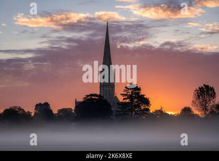 Oktober nebliger Morgenaufgang hinter der Salisbury Cathedral von den Harnham Water Meadows Wiltshire Südwesten Englands Stockfoto