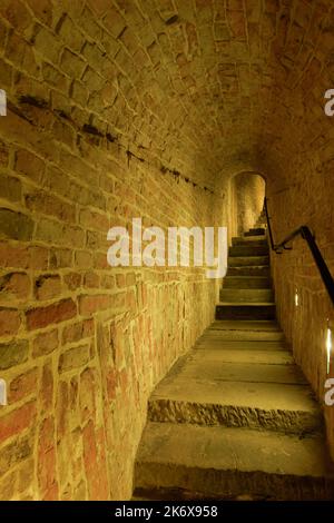 Innenansicht des alten Schlosses schmale Treppe um eine Ziegelmauer. Stockfoto