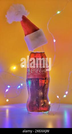 Rom Italien. September - 06. 2020. Coca-Cola-Glaskachelchen in einem Weihnachtshut auf gelbem Hintergrund Stockfoto