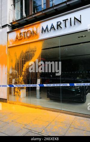 Park Lane, London, Großbritannien. 16. Okt 2022. Mitglieder von Just Stop Oil sprühen gelbe Farbe über die Aston Martin-Händler in der Park Lane. Kredit: Matthew Chattle/Alamy Live Nachrichten Stockfoto