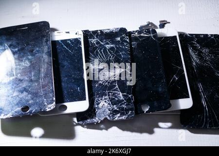 Mobiles Tablet mit einem zerbrochenen, stark zerbrochenen Glas auf dem Touchscreen. Intelligenter Austausch von Hardwareteilen, Befestigungskonzept Stockfoto