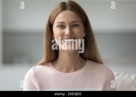 Headshot glücklich schöne Frau sitzen auf dem Sofa starrte auf die Kamera Stockfoto