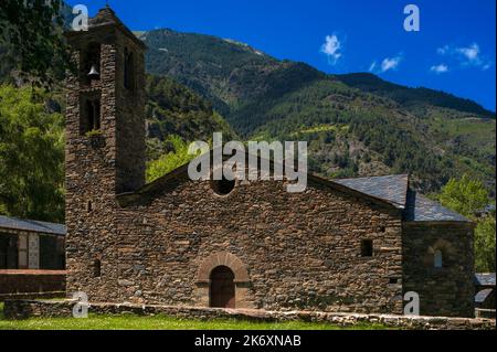 Església de Sant Martí (Kirche St. Martin), eine mittelalterliche romanische Kirche in La Cortinada im Ordino-Tal in Andorra. Die Kirche wurde in den 1000s und 1100s v. Chr. erbaut und steht inmitten zerklüfteter, aber gut bewaldeter Hänge in den östlichen Pyrenäen. Es hat Schutt Wände, einen zweistöckigen Glockenturm und ein Dach mit Fischschuppen. Stockfoto