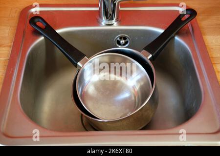 Edelstahlpfannen im Küchenwaschbecken - Draufsicht Stockfoto