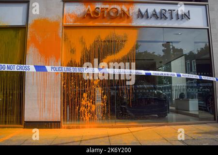 London, England, Großbritannien. 16. Oktober 2022. Aktivisten von Just Stop Oil bedeckten den Aston Martin Showroom in Park Lane mit orangefarbener Farbe, während die Klimaschutzgruppe ihre Proteste fortsetzt und fordert, dass die Regierung die Ausstellung von Lizenzen für fossile Brennstoffe einstellt. (Bild: © Vuk Valcic/ZUMA Press Wire) Stockfoto